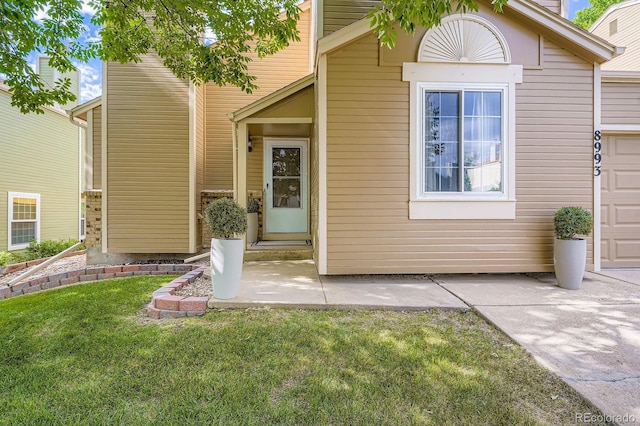 8993 W 88th Pl, Westminster, CO 80021 - view of exterior entry featuring a lawn and a patio area