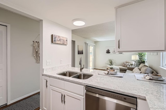 8993 W 88th Pl, Westminster, CO 80021 - kitchen featuring stainless steel dishwasher, white cabinets, light stone counters, healthy amount of natural light, and a textured ceiling