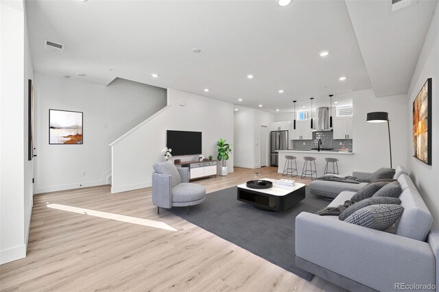 living room with sink and light wood-type flooring