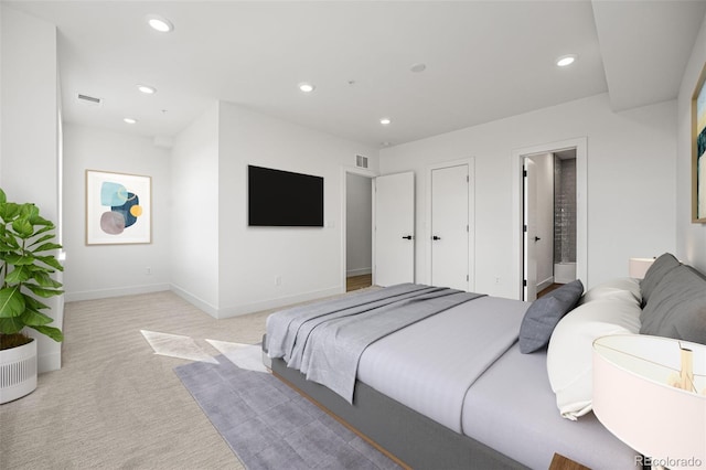 bedroom featuring light colored carpet and connected bathroom