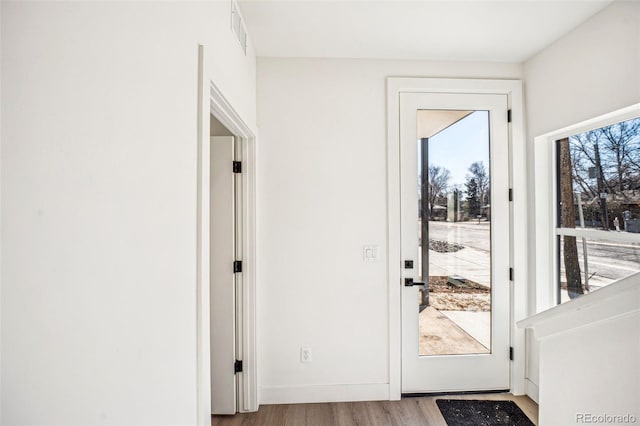 entryway featuring baseboards, visible vents, and wood finished floors