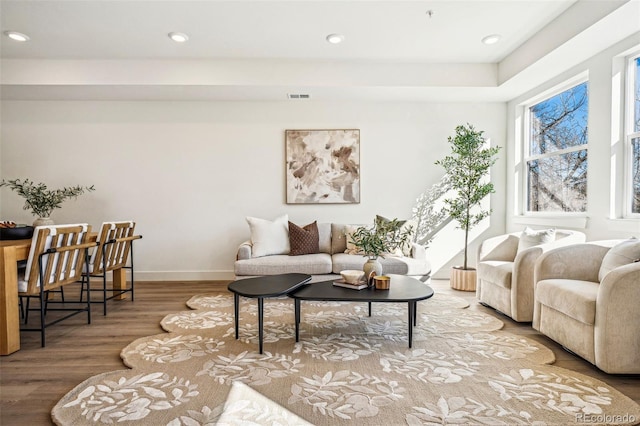 living room featuring recessed lighting, visible vents, baseboards, and wood finished floors