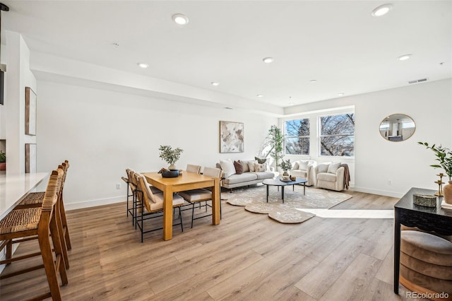 living area with recessed lighting, baseboards, visible vents, and light wood finished floors