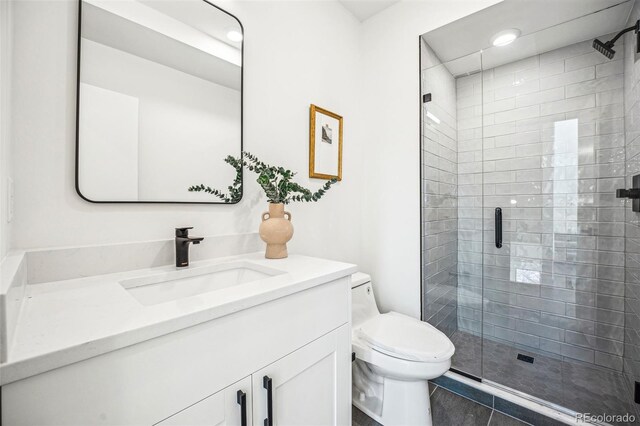 full bath featuring vanity, a shower stall, and toilet