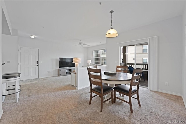 dining area featuring light carpet and ceiling fan