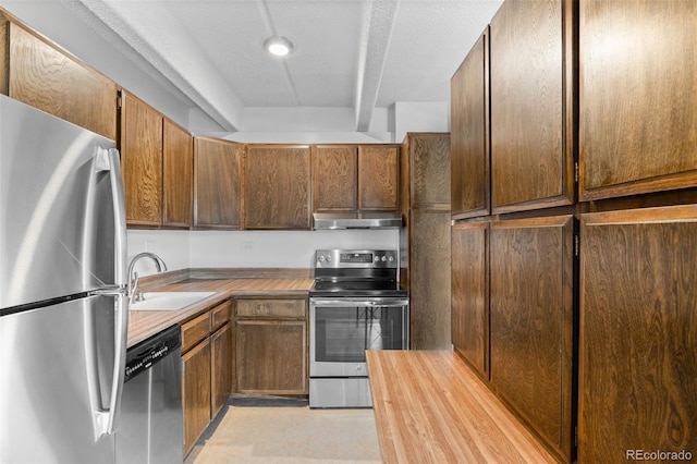 1255 N Ogden St Unit 406, Denver, CO 80218 - kitchen with stainless steel appliances, under cabinet range hood, and butcher block counters