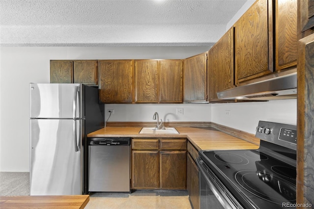 1255 N Ogden St Unit 406, Denver, CO 80218 - kitchen with appliances with stainless steel finishes, under cabinet range hood, a textured ceiling, light countertops, and brown cabinetry
