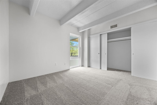 1255 N Ogden St Unit 406, Denver, CO 80218 - unfurnished bedroom with beam ceiling, carpet, a textured ceiling, and a closet