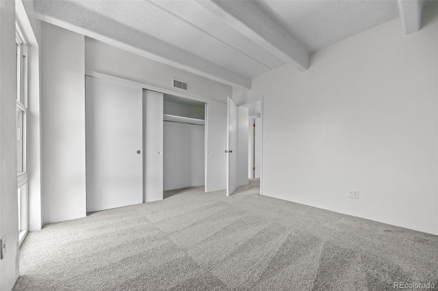 1255 N Ogden St Unit 406, Denver, CO 80218 - unfurnished bedroom featuring carpet floors, a textured ceiling, beamed ceiling, and a closet