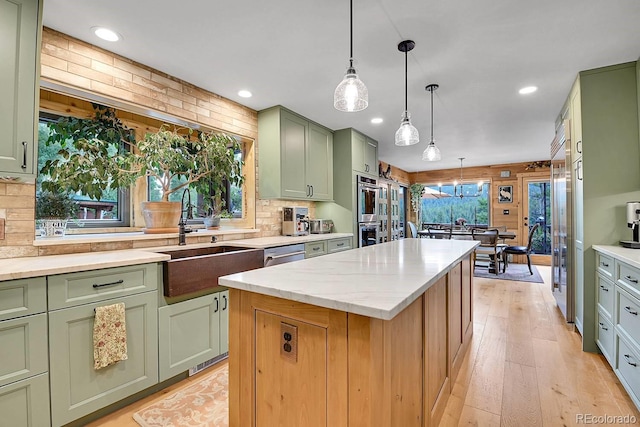 31112 Shadow Mountain Dr, Conifer, CO 80433 - kitchen with green cabinetry, a kitchen island, decorative backsplash, decorative light fixtures, and light wood-style flooring