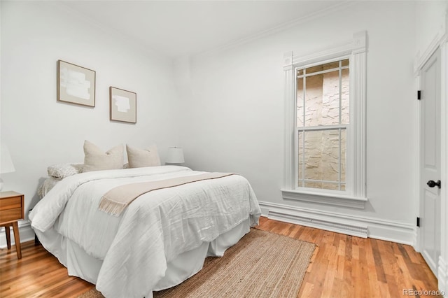 bedroom featuring wood-type flooring and baseboard heating