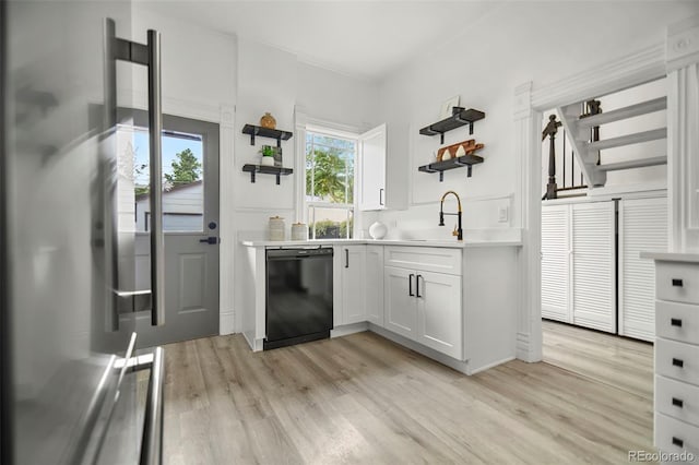 kitchen featuring light wood-type flooring, stainless steel fridge, dishwasher, sink, and white cabinets