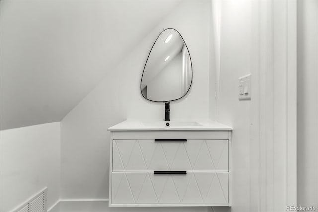 bathroom with lofted ceiling and vanity