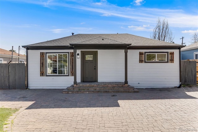view of front of property with fence and roof with shingles