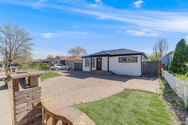 back of property featuring a patio, a gate, and a fenced backyard