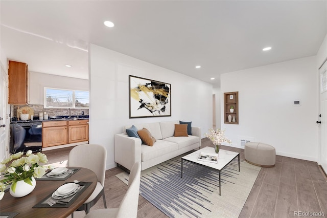living room with baseboards, recessed lighting, wood finished floors, and visible vents