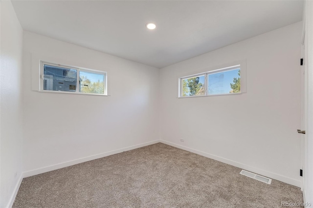 empty room with baseboards, carpet flooring, recessed lighting, and visible vents