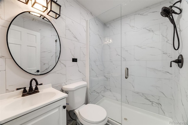 bathroom featuring toilet, tile walls, a shower stall, and vanity