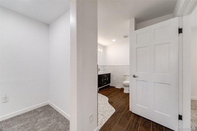 bathroom with vanity, toilet, baseboards, wood finished floors, and visible vents