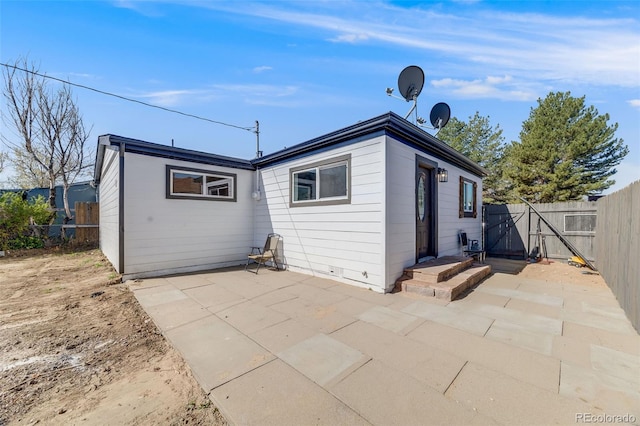 rear view of property featuring a fenced backyard and a patio area