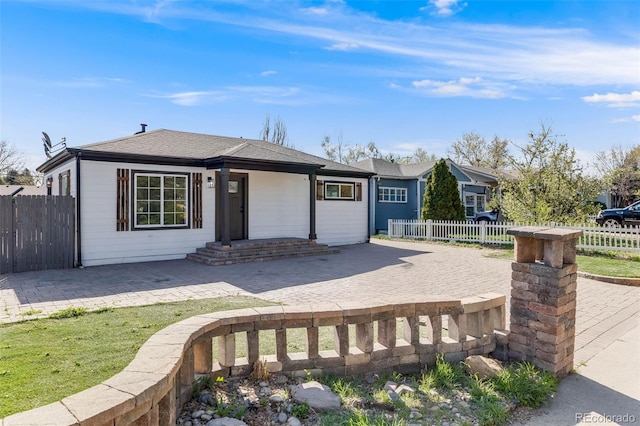 view of front of house featuring fence and a patio