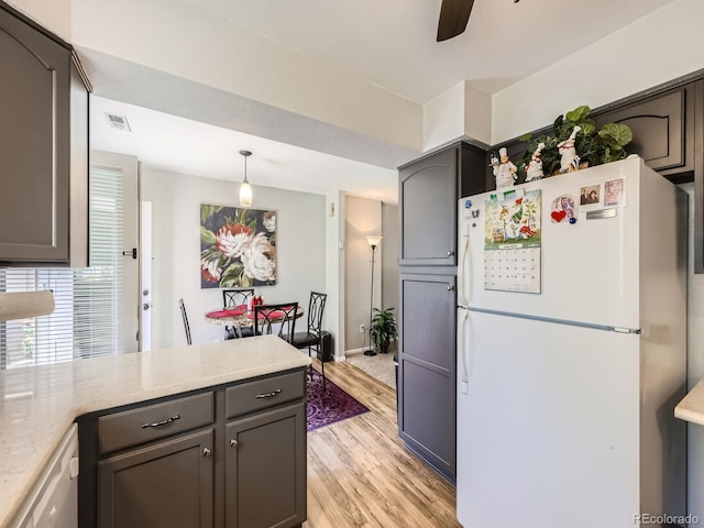 4121 W 111th Cir, Westminster, CO 80031 - kitchen featuring freestanding refrigerator, light wood-style floors, a ceiling fan, decorative light fixtures, and a peninsula