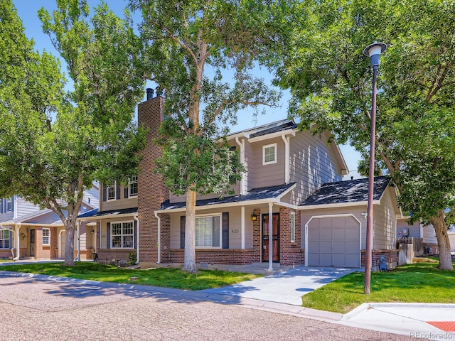 4121 W 111th Cir, Westminster, CO 80031 - view of front of property with brick siding, an attached garage, a chimney, driveway, and a front yard