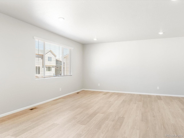 empty room with light hardwood / wood-style flooring