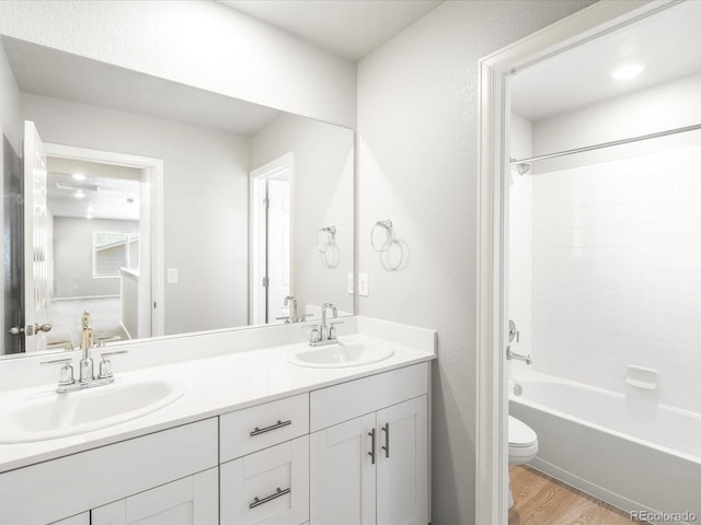 full bathroom with toilet, vanity, tub / shower combination, and hardwood / wood-style flooring