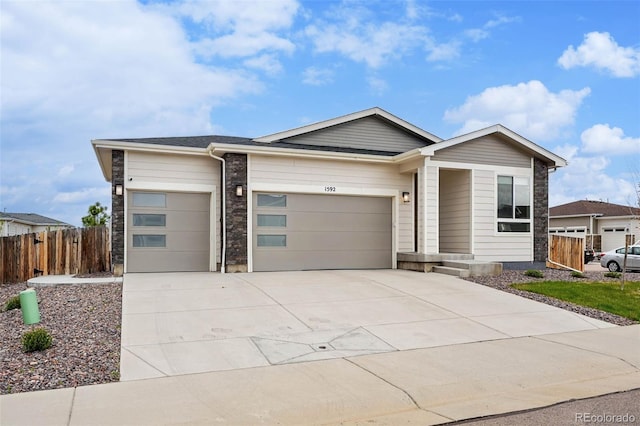 1592 Maggie Mae Ln, Castle Rock, CO 80104 - view of front of home with an attached garage, fence, concrete driveway, and stone siding