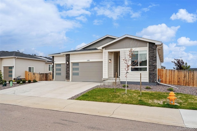 1592 Maggie Mae Ln, Castle Rock, CO 80104 - view of front of property featuring fence, an attached garage, driveway, and stone siding