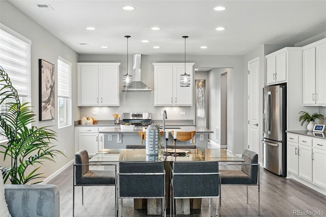 1592 Maggie Mae Ln, Castle Rock, CO 80104 - kitchen with stainless steel fridge, wall chimney range hood, wood finished floors, recessed lighting, and baseboards
