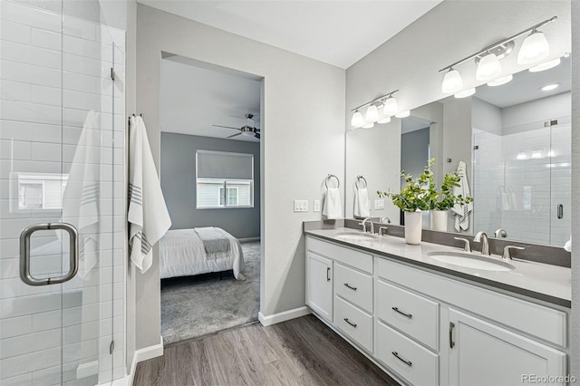 1592 Maggie Mae Ln, Castle Rock, CO 80104 - ensuite bathroom featuring wood finished floors, a stall shower, ceiling fan, double vanity, and baseboards