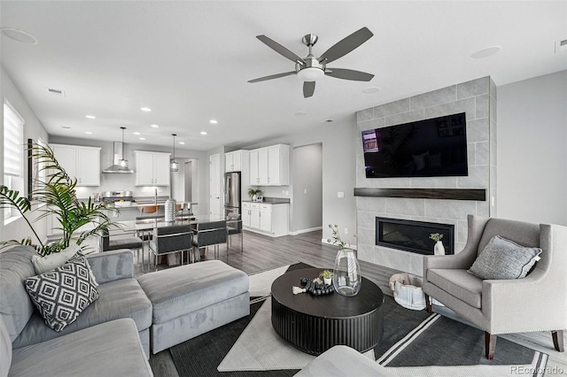 1592 Maggie Mae Ln, Castle Rock, CO 80104 - living area featuring ceiling fan, dark wood-style flooring, recessed lighting, a tiled fireplace, and baseboards