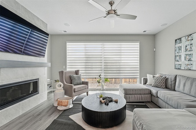 1592 Maggie Mae Ln, Castle Rock, CO 80104 - living area featuring wood finished floors, a tiled fireplace, and ceiling fan