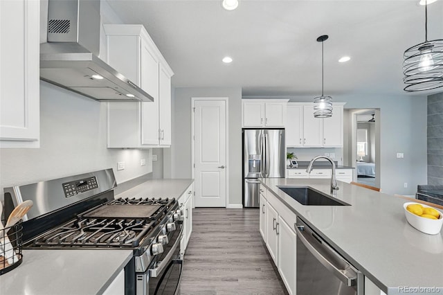1592 Maggie Mae Ln, Castle Rock, CO 80104 - kitchen featuring appliances with stainless steel finishes, a sink, wall chimney exhaust hood, white cabinets, and recessed lighting