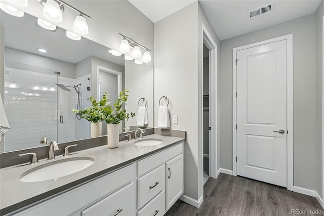 1592 Maggie Mae Ln, Castle Rock, CO 80104 - full bathroom featuring baseboards, a stall shower, double vanity, and wood finished floors