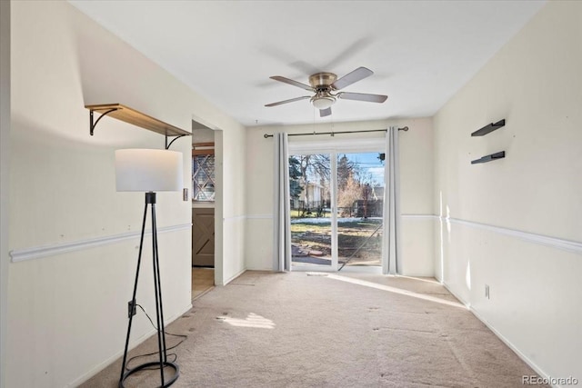 empty room featuring ceiling fan and light colored carpet