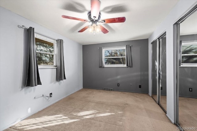 carpeted spare room with ceiling fan and a healthy amount of sunlight