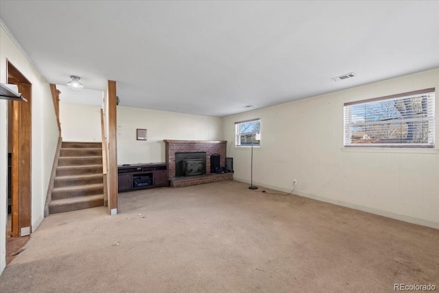 unfurnished living room with a wealth of natural light, a fireplace, and light carpet