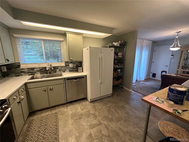 kitchen featuring stainless steel appliances, sink, decorative light fixtures, and decorative backsplash