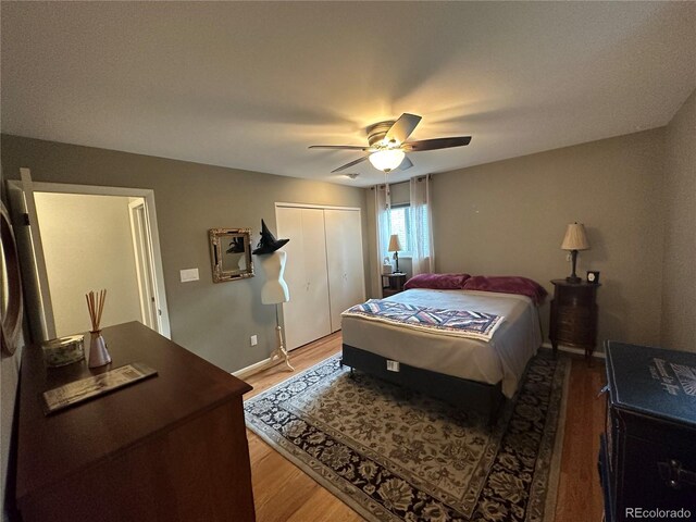 bedroom featuring ceiling fan, a closet, and hardwood / wood-style flooring