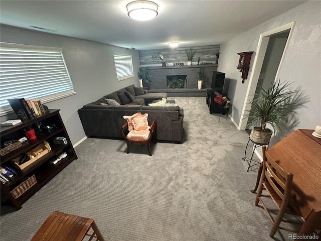 living room featuring a large fireplace and carpet flooring