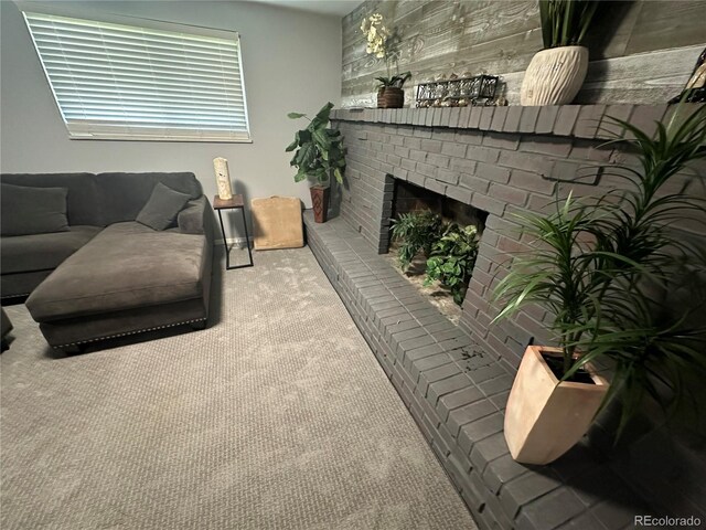 carpeted living room with a brick fireplace