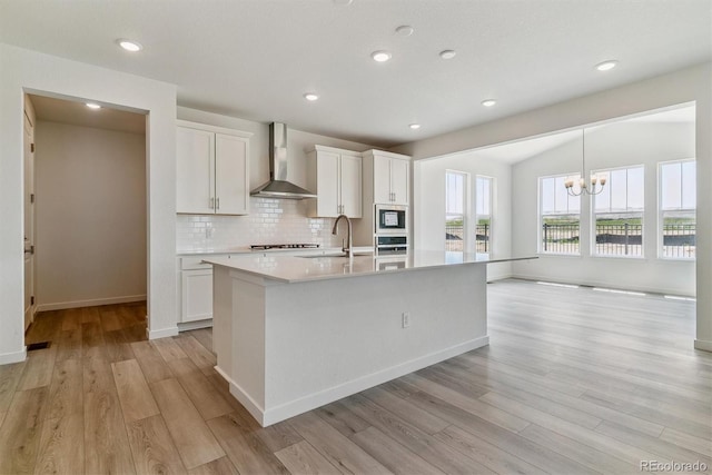 25254 E Warren Pl, Aurora, CO 80018 - kitchen with wall chimney exhaust hood, appliances with stainless steel finishes, tasteful backsplash, light wood finished floors, and recessed lighting
