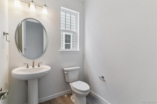25254 E Warren Pl, Aurora, CO 80018 - half bath featuring wood finished floors, baseboards, and toilet