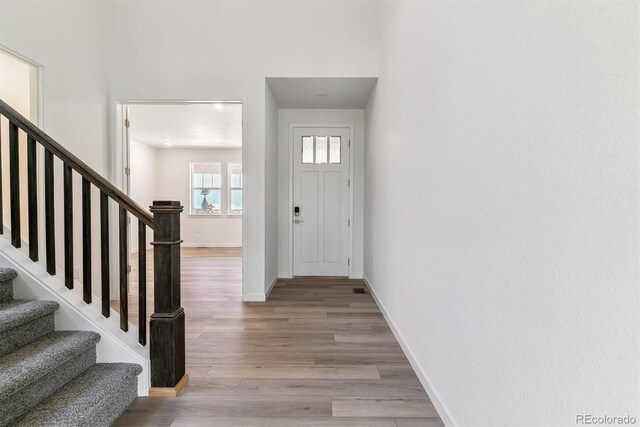 25254 E Warren Pl, Aurora, CO 80018 - entrance foyer with stairs, light wood-style flooring, and baseboards