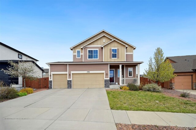 12766 Sunlight Peak Pl, Peyton, CO 80831 - craftsman-style house with a porch, board and batten siding, stone siding, concrete driveway, and an attached garage