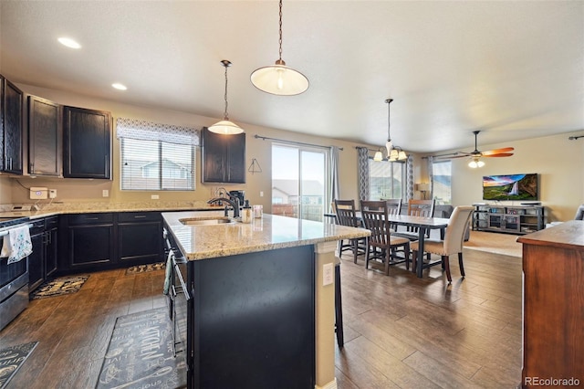 12766 Sunlight Peak Pl, Peyton, CO 80831 - kitchen with a sink, dark wood finished floors, a kitchen island with sink, electric stove, and light stone countertops