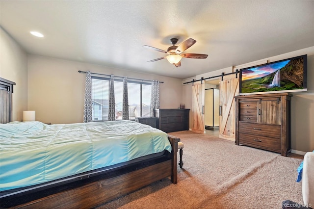 12766 Sunlight Peak Pl, Peyton, CO 80831 - bedroom with a barn door, carpet flooring, and a ceiling fan